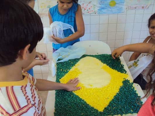 crianças montando a bandeira do Brasil com papel crepom