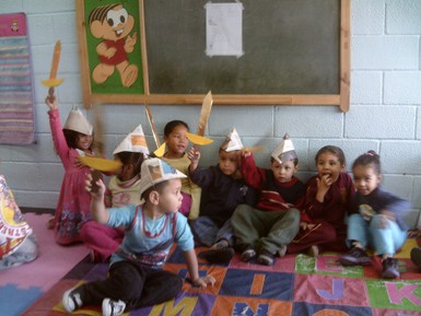 crianças usando chapéu e espadinhas de jornal