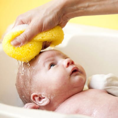 primeiro banho do bebê usando esponja
