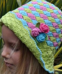 menina com chapeu colorido em azul, rosa e verde com aplique de tres mini rosass