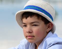 menino com chapeu na cor cru com faixa de crochê azul