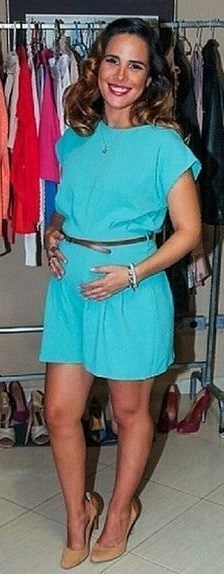 Vanessa Camargo, veste macaquinho azul claro com cintinho e sandália de salto.