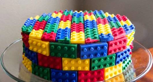 Bolo lego coberto por várias peças coloridas.