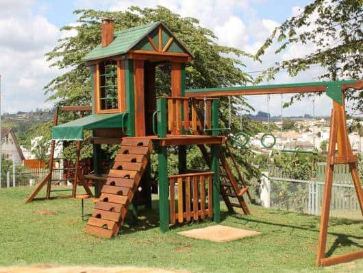 Playground de madeira com algumas tábuas em verde.