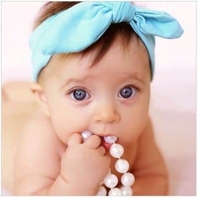 Bebê usa turbante na cor azul claro de laço.