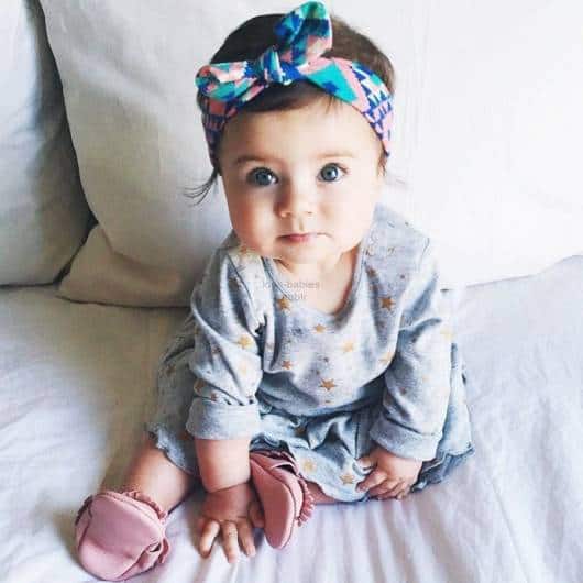 Bebê veste turbante estampado na cor azul com lacinho.