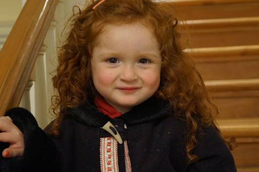 menina ruiva usando penteados para cabelo cacheado infantil