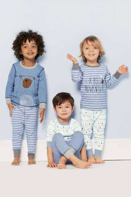 Meninos vestindo pijamas com estampas iguais.