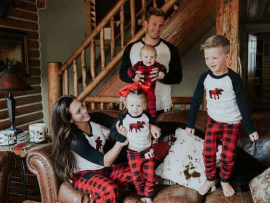 Pai, mãe e filhos com pijamas iguais.