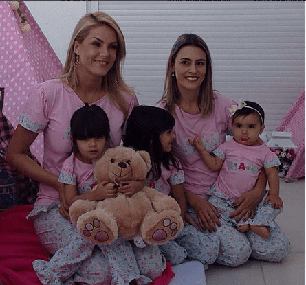 Duas mulheres e três meninas com pijamas personalizados.