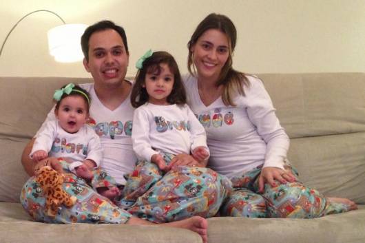 Mãe, pai e filhas com o mesmo pijama.