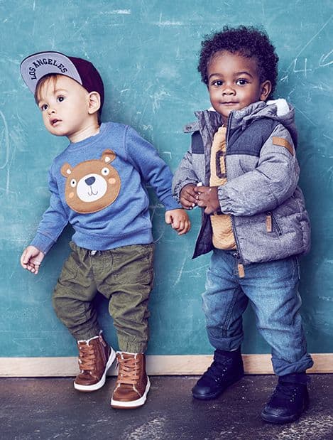 Dois meninos vestindo conjuntos de inverno.