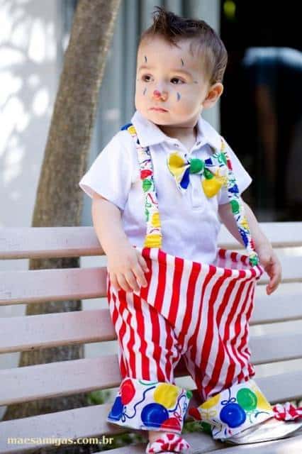 Criança vestida de palhaço, com rosto pintado.