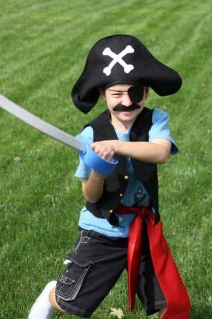 Menino com espada e chapéu de pirata.