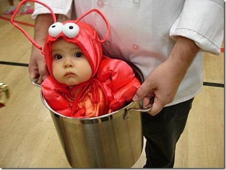 Bebê vestido de lagosta dentro de balde.