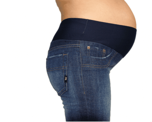 Modelo grávida mostra calça jeans adaptada com elástico na cintura.