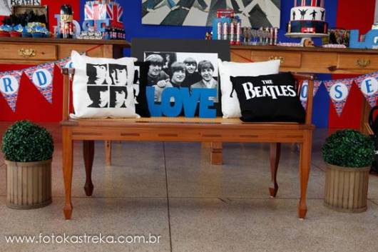 Banco com almofadas dos The Beatles para decoração.