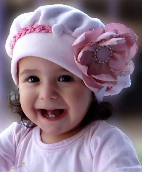 bebê com gorro rosa com flor