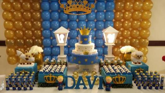 Mesa de bolo decorado com as cores azul, dourado e branco.