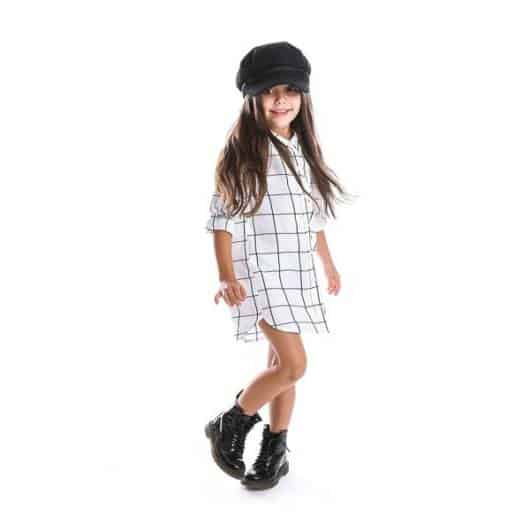Look com vestido xadrez infantil preto e branco e boina preta